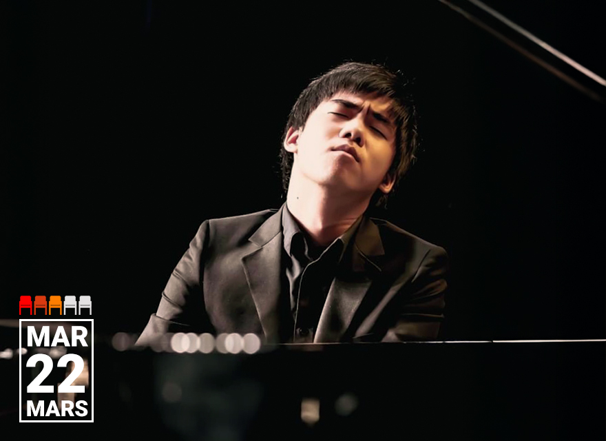 The image shows a musician seated at a piano, wearing formal attire and appearing deeply focused and emotive while performing. The setting suggests a concert or recital, with the dark background emphasizing the intensity of the moment.