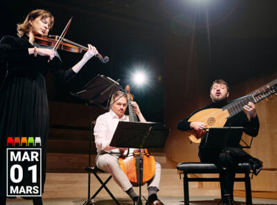 This image shows members of the Baroque Ensemble Francoeur performing on stage. The ensemble includes a violinist, a viol player, and a lutenist. The violinist stands while playing, the viol player and the lutenist are seated with their instruments. They are all focused on their performance, with music stands in front of them. The background is dimly lit, with a spotlight highlighting the performers. The date "Mar 01" is prominently displayed in the lower left corner.